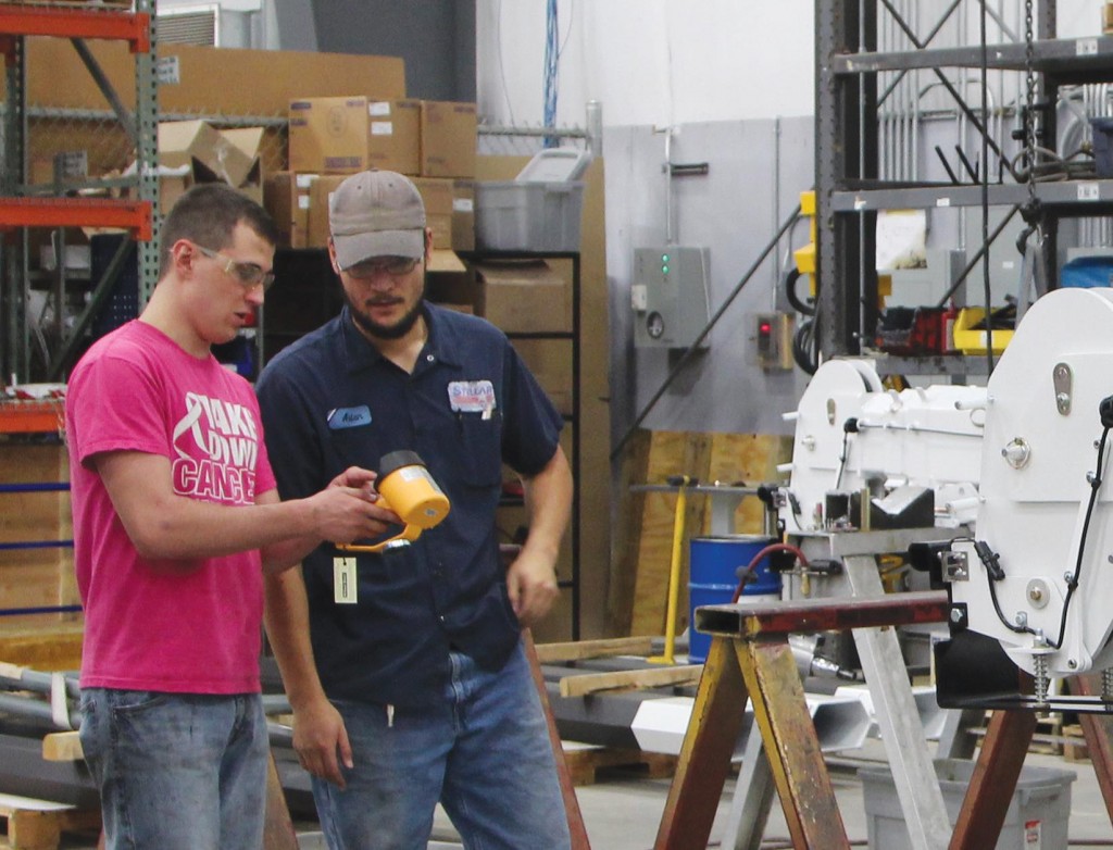 Two Stellar employees discuss the final steps during a crane assembly.