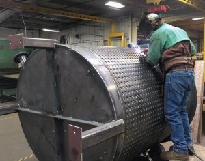Air Control employee Jake Huff welds a dimple plated jacket onto a vessel for a roofing manufacturing customer.